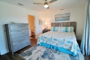 ein Schlafzimmer mit einem Bett und einer Kommode in der Unterkunft Shore Beats Work in Mexico Beach