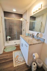 ein Bad mit einem Waschbecken und einer Dusche mit einem Spiegel in der Unterkunft Shore Beats Work in Mexico Beach