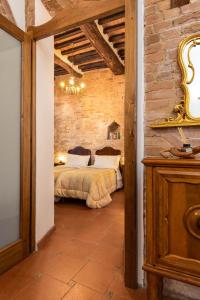 1 dormitorio con 1 cama en una pared de ladrillo en Il Chiostro, en Siena