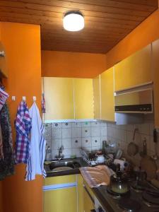 eine Küche mit gelben Schränken und einem Waschbecken in der Unterkunft Apartment mit toller Aussicht in Bad Liebenzell