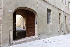 una entrada a un edificio con puerta de madera en Il Chiostro, en Siena
