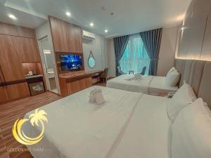 Habitación de hotel con 2 camas y TV de pantalla plana. en HO TRAM GOLDEN HOTEL, en Thuận Biên