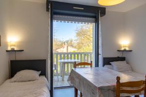 Duas camas num quarto com varanda em Appartement T1 à 300m des thermes de Barbotan em Barbotan-les-Thermes