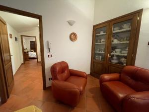 a living room with two leather chairs and a cabinet at B&B San Biagio in Marola