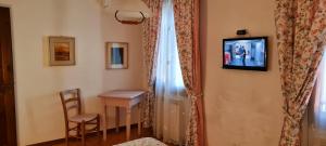 a room with a table and a television on a wall at Hotel Il Casolare in Noghera