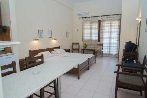 a room with a table and chairs and a kitchen at Fokion Studios in Lakíthra