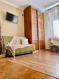 ein Wohnzimmer mit einem Sofa und einem TV an der Wand in der Unterkunft Apartment on Virmenska 14Вул Вірменська Центр in Lwiw