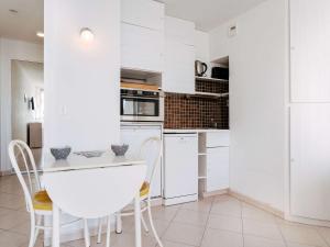 a kitchen with white cabinets and a table and chairs at Studio Carnac, 1 pièce, 2 personnes - FR-1-477-15 in Carnac