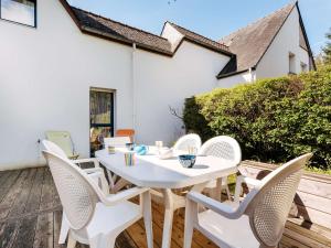 einen weißen Tisch und Stühle auf einer Holzterrasse in der Unterkunft Villa Carnac, 4 pièces, 6 personnes - FR-1-477-54 in Carnac