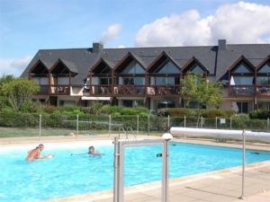 2 Personen schwimmen in einem Pool in einem Hotel in der Unterkunft Villa Carnac, 4 pièces, 6 personnes - FR-1-477-54 in Carnac