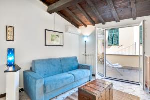 een woonkamer met een blauwe bank en een tafel bij Il Borgo dei Ricordi, Terre Marine in Corniglia