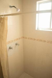 La salle de bains est pourvue d'une douche et d'une fenêtre. dans l'établissement Bonita y cómoda casa cerca del consulado., à Ciudad Juárez