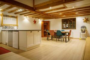 cocina y comedor con mesa y sillas en Gîte avec piscine chauffée & aires de jeux pour enfants, en Barberaz