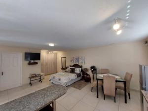 Una sala de estar con una cama, una mesa y sillas. en Lyn's Self Catering, en Swakopmund