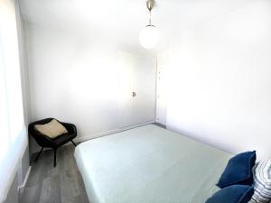 ビトリア・ガステイスにあるLuxury Cercas Bajas Vitoriaのベッドと椅子付きの小さな部屋です。