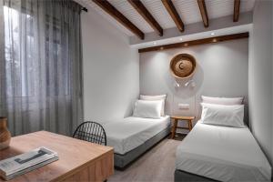 een kamer met 2 bedden en een tafel en een tafel bij Coel Luxury Suites by RentalsPro Services - Potidea Halkidiki in Nea Potidaea