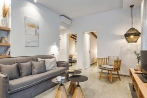 een woonkamer met een bank, stoelen en tafels bij Coel Luxury Suites by RentalsPro Services - Potidea Halkidiki in Nea Potidaea