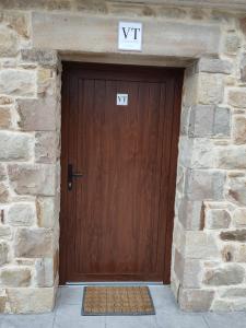 una puerta de madera con un cartel en la parte superior en Etxezarre, en Ajangiz (Urdaibai), en Ajangiz