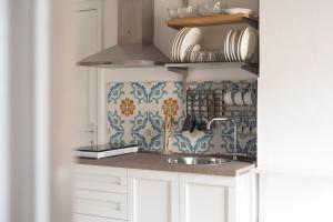 a kitchen with white cabinets and a sink at Casa degli Ospiti in Alimena +6 photos
