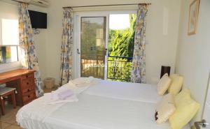 a bedroom with a large white bed and a window at LULA VILLA in Ayia Napa