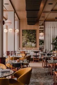 a restaurant with tables and chairs and a large window at The Comodo Bad Gastein, a Member of Design Hotels in Bad Gastein