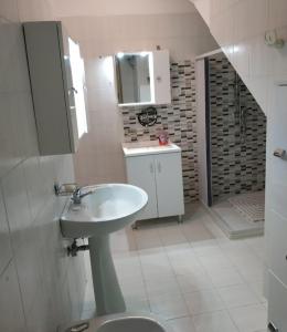Baño blanco con lavabo y espejo en La casa nel Borgo, en Bella