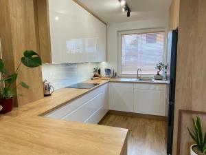 a kitchen with white cabinets and a sink and a window at Jaśminowa 17 in Gdynia