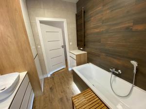 La salle de bains est pourvue d'une baignoire blanche et d'un lavabo. dans l'établissement Jaśminowa 17, à Gdynia