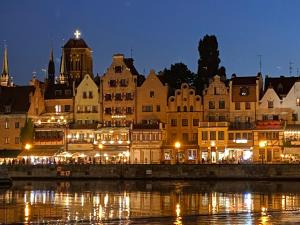 a group of buildings next to a river at night at Jaśminowa 17 in Gdynia