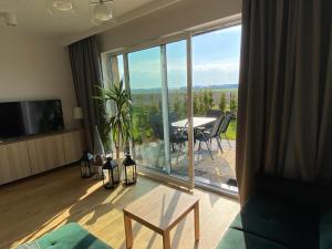 a living room with a table and a large glass window at Jaśminowa 17 in Gdynia