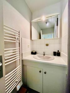a white bathroom with a sink and a mirror at Le Briantais in Saint Malo
