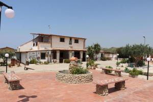 a group of benches in front of a building at Casa Vacanza Villa Sole Montallegro in Siculiana