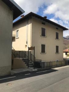 a building with stairs and a fence next to a street at Casa vacanza 1 in Serina