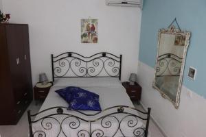 a bedroom with a black bed and a mirror at Casa Vacanza Villa Sole Montallegro in Siculiana +21 photos