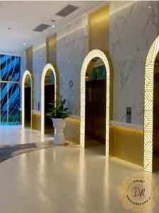 a lobby with yellow and white walls and a plant in a vase at ARTE Mont Kiara Relax & Go_Jacuzzi in Kuala Lumpur
