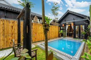 una casa con piscina e recinzione in legno di Lover's Retreat Villa Hoi An a Hoi An