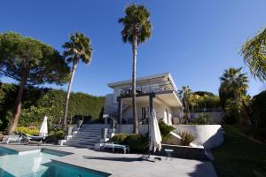 ein Haus mit einem Pool und Palmen in der Unterkunft Serendipity in Vallauris