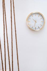 a clock on a white wall with ropes at Apulia Charming Suites - Casa Lonfo Suite Sole in Monopoli