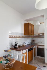 uma cozinha com armários de madeira e uma mesa em A Casa Scipione em Formia