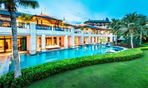 an exterior view of a house with a swimming pool at Raffles Hainan Clear Water Bay in Sanya