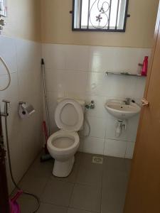 a bathroom with a toilet and a sink at T'Rai Homestay in Dungun