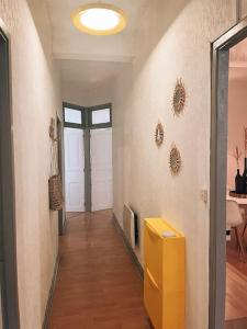 a hallway with a yellow table in a room at Appartement chaleureux au centre du village in Montesquieu-Volvestre