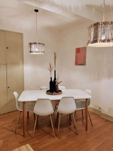 comedor con mesa blanca y sillas en Appartement chaleureux au centre du village, en Montesquieu-Volvestre