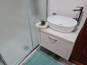 y baño con lavabo blanco y espejo. en Sicilia Mount&Sea, en Mascali