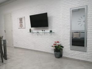 biała ceglana ściana z telewizorem z płaskim ekranem w obiekcie Casa Stefire 1 Pachino centro w mieście Pachino