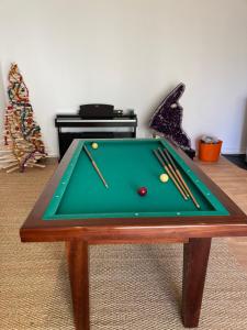 a green pool table with cue balls on it at Le Manoir des Sables - Chambre familiale grand confort in Berthegon