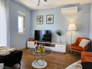 a living room with a tv and a table at Guest House Bona Dea - Trogir Area in Marina
