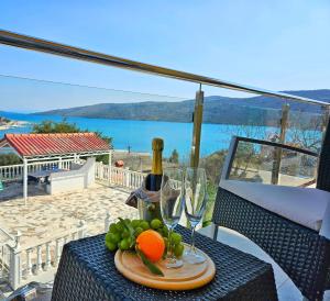 a table with a bottle of wine and a plate of fruit at Guest House Bona Dea - Trogir Area in Marina
