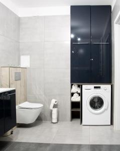 a bathroom with a washing machine and a toilet at Apartament Rodzinny in Lesko