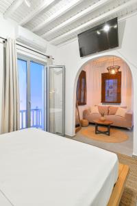 a bedroom with a bed and a living room at Oikia Suites Mykonos in Mýkonos City